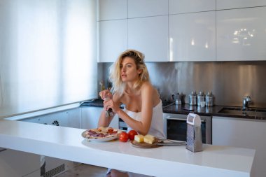Seksi ev hanımı. Sıcak bir mutfakta sabah kahvaltısı hazırlayan seksi, güzel bir kadın. Modern mutfak iç mimarisi