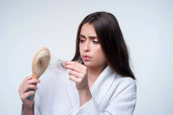 Closeup hair loss, hair fall in hairbrush, stress problem of woman with a comb