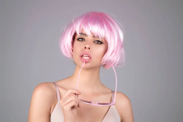 Funny girl with pink wig. Portrait of beautiful young woman with hairstyle. Closeup photo of amazing hairdo lady, isolated studio background. Portrait of caucasian female model