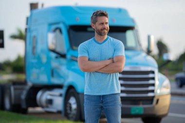 Kamyonun yanında erkek sürücü var. Erkek kamyonet sahibi. Ciddi bir orta yaşlı kamyoncu kamyoncu. Ulaşım endüstrisi araçları. Kamyonun önündeki yakışıklı adam.