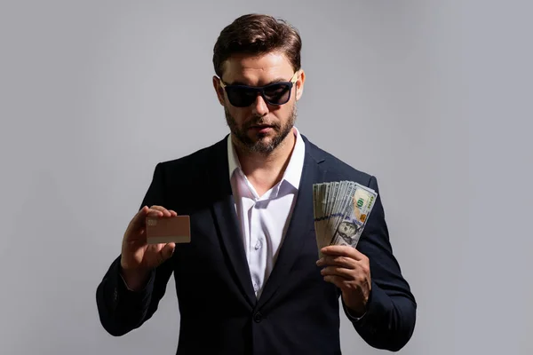 Man holding cash money in dollar banknotes on gray. Studio portrait of businessman with bunch of dollar banknotes. Dollar money concept. Career wealth business. Cash dollar banner