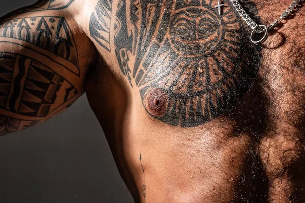 Accessories for men. Man with tattoo on chest skin. Hipster with chain silver necklace. Style and fashion. Brutal appearance. Tattooed chest and arm close up. Art of tattoo. Tattoo master concept.
