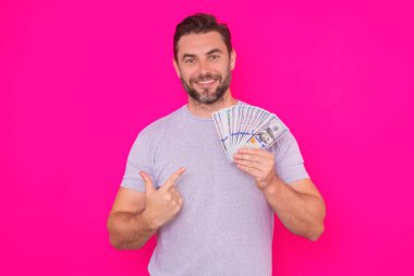 Çekici bir iş adamı para sayıyor. 100 dolarlık banknotlar tutan yakışıklı orta yaşlı bir adam. Parası olan başarılı bir iş adamı. Kâr ve finansal başarı. Dolar nakiti olan zengin bir adam.