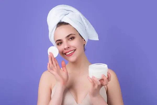 Removing makeup with cotton pads. Cleaning face with pad. Cosmetic cotton pad. Young woman caring for facial skin using cotton pad in studio. Beauty care and pampering. Daily skincare
