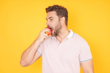 Elmalı insanlar. Stüdyo arka planında izole edilmiş elma yiyen insan portresi. Doğal vitamin, diyet ve sağlıklı yaşam için sağlıklı elma meyvesi. Güçlü bir adamın stüdyo portresi yeşil elma yiyor.