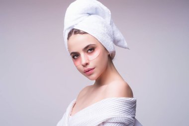 Kolajen hidrojel göz bantları, silikon bantlar. Göz altı nemlendirici bantlı cilt. Spa bakımı, kozmetoloji. Göz altı yamaları kullanan genç bir kadın.