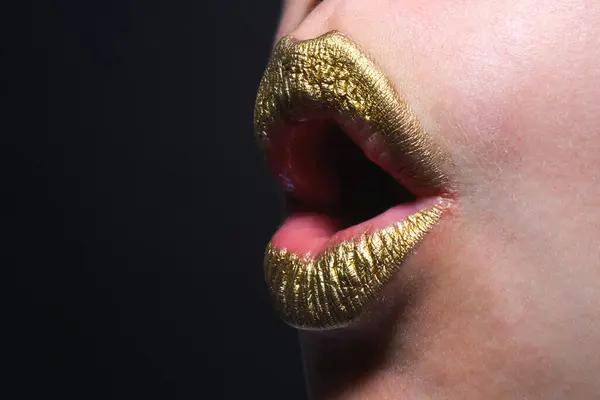 Surprised mouth. Close up female plump lips with gold. Golden glitter lipstick. Shine style for sexy lip. Sensual woman lips. Luxury golden mouth. Glamour gold lips