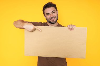 Promosyon gösteren orta yaşlı bir adam. Boş tahta kavramına parmak basmak. Kopyalama uzayı olan boş tabela. Reklam konsepti. Fotokopi alanı olan reklam panosu, boş model. Boş tabela, pano