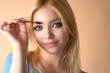 Kahverengi kaşları şekillendiren kadın model. Güzel kaşları olan kadın gözü. Mükemmel şekilli kaş, kaş jöleli kirpikleri. Kaşları boya.