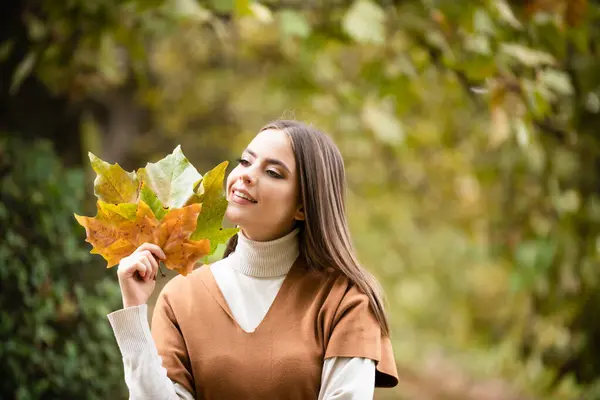 Autumn romance woman with leaves. Female model on foliage day. Dream and lifestyle. Beauty outdoor portrait. Carefree gorgeous sensual natural tender charming girl with leaf on face. Fall nature