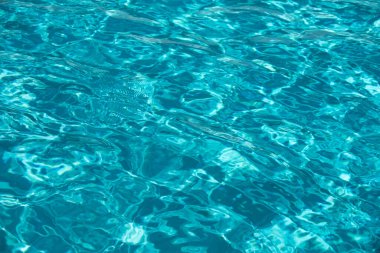 Su arka planı, dalgalanma dalgaları. Mavi yüzme havuzu deseni. Deniz yüzeyi. Yüzme havuzunda su ve güneş yansıması. Kopyalama alanı olan pankart