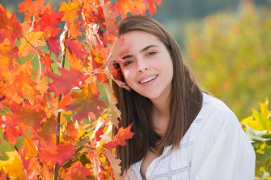 Sonbahar yapraklı genç bir kadının portresi. Romantik kız rüyası, sonbahar akçaağaç yapraklarını tut. Sonbahar mevsimi
