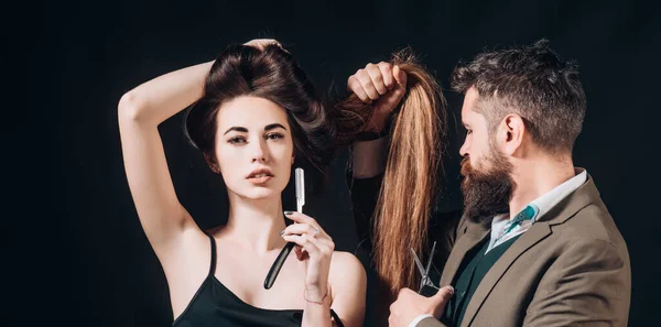 Hairdresser makes hair style with hair care products. Hairdresser making hairstyle, haircut. Woman with long hair at beauty salon. Barber cutting hair with scissors