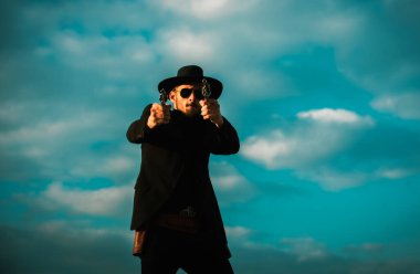 Siyah takım elbiseli, tabanca tabancası ve mühimmatı olan şerif ya da kovboy. Amerikan batı şerifi. Kovboyla Vahşi Batı