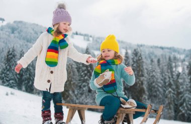 Oğlan ve kız, karlı bir ormanda kızak kayıyorlar. Açık hava kış çocukları Noel ve yeni yıl için eğlencelidir. Çocuklar kızakla gezintiye çıkıyor. Kış çocukları eğlence