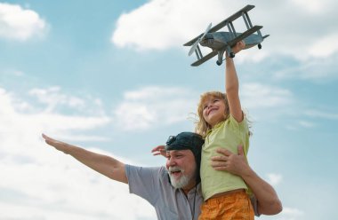 Genç torun ve yaşlı büyükbaba gökyüzünde arka planda fotokopi uzayıyla eğleniyorlar. Çocuk uçmayı hayal eder, büyükbabayla mutlu bir çocukluk.