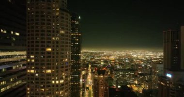 Los Angeles şehir merkezinin hava manzaralı görüntüsü alacakaranlıkta gökyüzüne yükseliyor. Ünlü gökdelenler