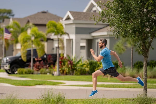 フィットネスモデルワークアウトを屋外にフィットさせます 男は運動のために走って通りを走る 春の朝に走っている男 ランニングマン 男性ランナージョギング 外で訓練してる スポーツ 心臓の概念 — ストック写真