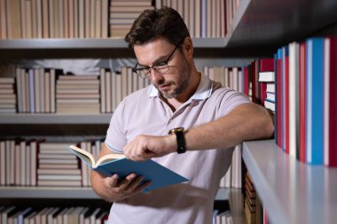 Orta yaşlı bir öğretmen ya da kütüphanede kitap okuyan bir profesör. Öğretmenler günü. Öğretmenim sınıfta. Yakışıklı öğretmenlerle bilgi ve eğitim. Sınıfta kitabı olan bir öğretmen. Öğretmen derste.