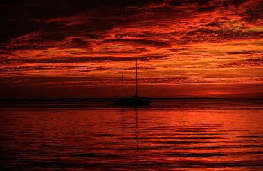Yaz yat gezisi. Günbatımında yelkenliler. Okyanus yatı suda yüzüyor.