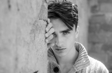 Genç şık yakışıklı adam gri duvarda poz veriyor. Erkek portresi