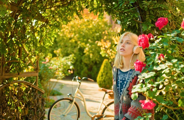 Active leisure and lifestyle. Girl ride bicycle for fun. Blonde enjoy relax in park or garden. Active girl with bicycle. Motion and energy. Woman with bicycle in blooming garden. Weekend activity.