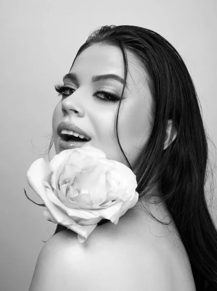 Beautiful woman with rose flower. Pink lips and rose. Beauty girl. Sensual sexy mouth