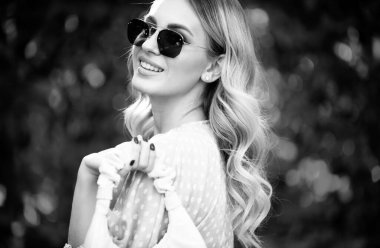 Açık havada güneş gözlüklü genç bir kadının portresi. Güzel yüzlü romantik kız.