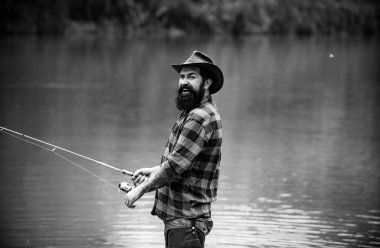 Balıkçı, dağ nehrinde olta balıkçılığı yapıyor. Ormandaki nehirde alabalık avlayan bir balıkçı.