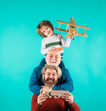 Erkek aile. Baba, büyükbaba ve çocuk mavi üzerine izole edilmiş. Oyuncak uçağı olan çocuk. Erkekler aile nesli
