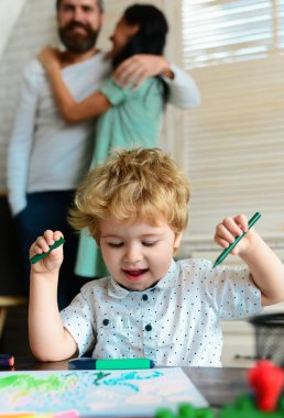 Çocuk sanatı, yaratıcılık, çocuk konsepti. Mutlu aile portresi çizimleri. Baba, anne ve çocuk bir evde bir araya gelirler. Çocuklar resim yapar
