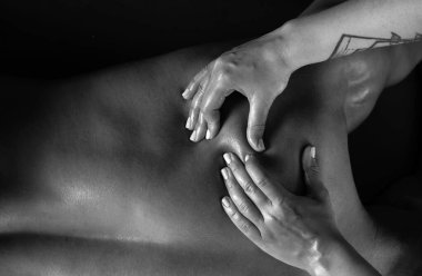 Omuz kası masajı. Masaj yapan kadının elleri, yakın plan. Spor masajı. Omuzlarıyla çalışan bir terapist. Kaplıcadaki masörden masaj alan adam.