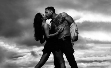 Çift öpüşmesi, şehvetli bir öpücük. Erkeğin kucaklaşması ve şehvetli bir kadını öpmesi. Güzel, genç bir çift dışarıda şehvetli bir şekilde sarılıyor. Güzel genç çift öpüşüyor ve sarılıyor.