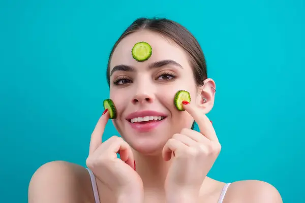 Facial mask of cucumber. Cosmetics, cosmetology, dermatology. Woman face with cucumber mask. Cosmetic procedure womans face in the mask with cucumber slices on face