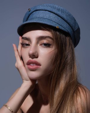 Seductive sexy lovely attractive young sensual woman with beauty face posing on studio background. Beautiful elegant sexy model with cap, studio portrait. Sensual beautiful woman face