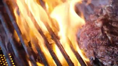 Izgarada ızgara et. Çiğ biftek bifteği ızgarada alevler içinde pişirmek için hazırlandı. Demir ızgarada biftek. Izgarada kızartılmış et. bbq ızgarasında kızartılmış et.