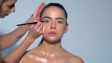 Kaşlarını doğal makyajla yapan beyaz bir kadının yakın portresi. Seksi mankeni telafi et. Makyaj sanatçısı güzel makyaj yapıyor. Profesyonel makyöz, cazibe modeli makyajı yapıyor.