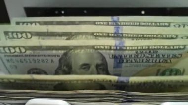 Banknotların içinde nakit para var. Bankacılık ve finansal konsept. Elektronik para sayacı ve yeni 100 dolarlık banknotlar. Sayaç makinesi 100 dolar banknot sayıyor.