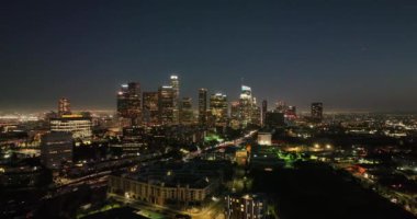 Los Angeles Ufuk Çizgisi Hava Aracı gecesi. Geceleri Los Angeles şehir merkezindeki gökdelenlerin hava görüntüleri. Şehir ışıkları ve bina kuleleri şehir sokakları ve trafiği olan bir insansız hava aracından.