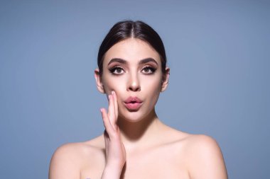 Kaşlarını kaldıran kız şaşırıyor ve şok oluyor. Beklenmedik haberlere şaşırmış bir tepki. Stüdyoda izole edilmiş tişörtlü bir kız. Yüzünde şok, şaşkınlık ve şaşkınlık ifadesi var.