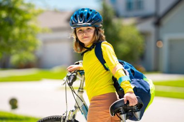 Küçük çocuk parkta bisiklete biniyor. Bisikletli bir çocuk. Bisiklet süren kasklı mutlu çocuk. Çocuk bisiklete binmeye başladı. Bisikletli bir çocuk bisiklet sürüyor. Çocuk bisikleti