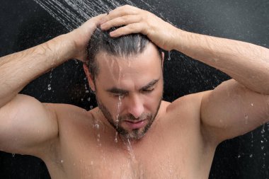 Adam sabah duşu alıyor. Duş başlığından dökülen saçlar. Duş alan adamı kapatın. Vücut bakımı hijyeni. Duş konsepti. Adam duşta su altında.