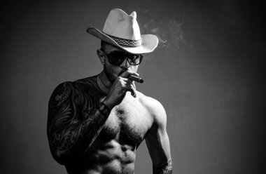 Seksi erkek yüzü. Gözlüklü, puro içen bir adam. Erkek güzelliği, moda portresi