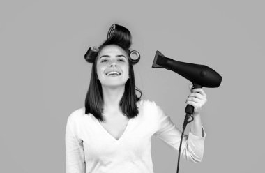 Woman with hair dryer after showering. Beautiful girl with straight hair drying hair with professional hairdryer