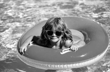 Yüzme havuzunda yaz tatili çocuğu. Çocuk Aquapark 'ta eğleniyor. Şişme lastik çemberdeki komik çocuk. Yaz zamanı. Çekim konsepti
