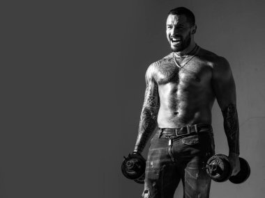 Dumbbell 'ın yanındaki adam. Vücut geliştiren kas geliştiren adam egzersiz yapıyor. Çıplak gövdeli kaslı seksi adam dambılla poz veriyor. Fitness konsepti. Erkek iri kıyım.