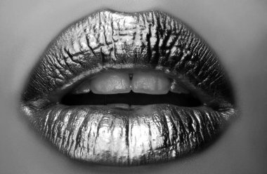 Altın dudaklar. Ağızdan gelen altın boya. Makyajlı kadın ağzında altın dudaklar. Altın metalik için duygusal ve yaratıcı tasarım. Altın tasarım