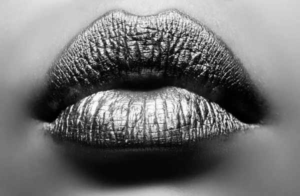 Gold lips. Woman wouth close up with golden color lipstick on lip. Glitter glossy lips biting