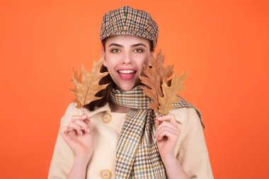 Sonbahar portresi yapan kadının sonbahar akçaağaç yaprakları stüdyoda izole edilmiş ve fotokopi alanı var. Sonbahar portresi, güz yapraklı, bereli ve sıcacık eşarplı neşeli bir kadın.