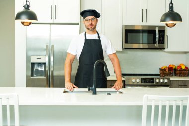 Aşçı mutfağa. Mutfakta üniformalı bir aşçı var. Sakallı şef, aşçı ya da fırıncı. Mutfak geçmişinde erkek aşçı. Mutfakta aşçı şapkası olan şef üniformalı yakışıklı bir adam.